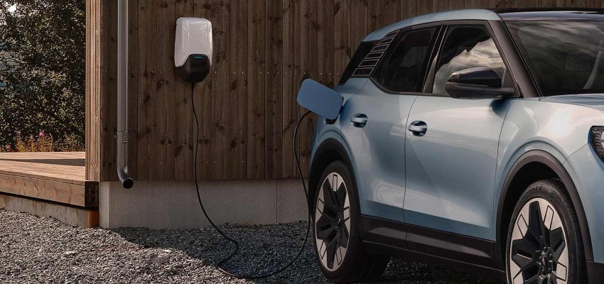 A blue Ford Explorer EV charges from a wall charger; EV home charger installation hub image