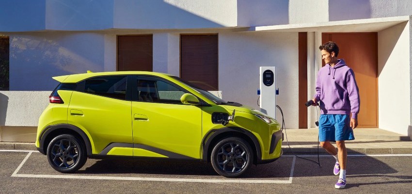 A man goes to charge a yellow BYD Dolphin Surf at the side of the road; How to charge an EV hub image