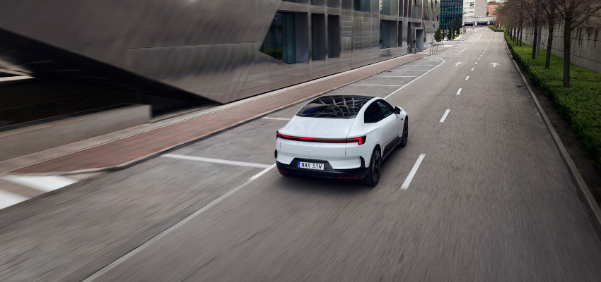 A white Polestar 4 drives along an empty road; Driving an electric car hub image