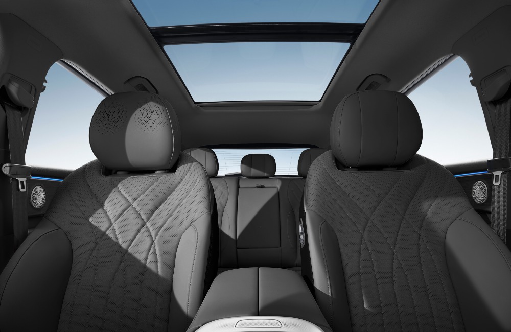 The interior of an OMODA 9, showing off the ambient lighting, comfortable seating, and unique headrest speakers.