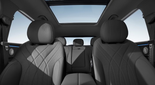 The interior of an OMODA 9, showing off the ambient lighting, comfortable seating, and unique headrest speakers.