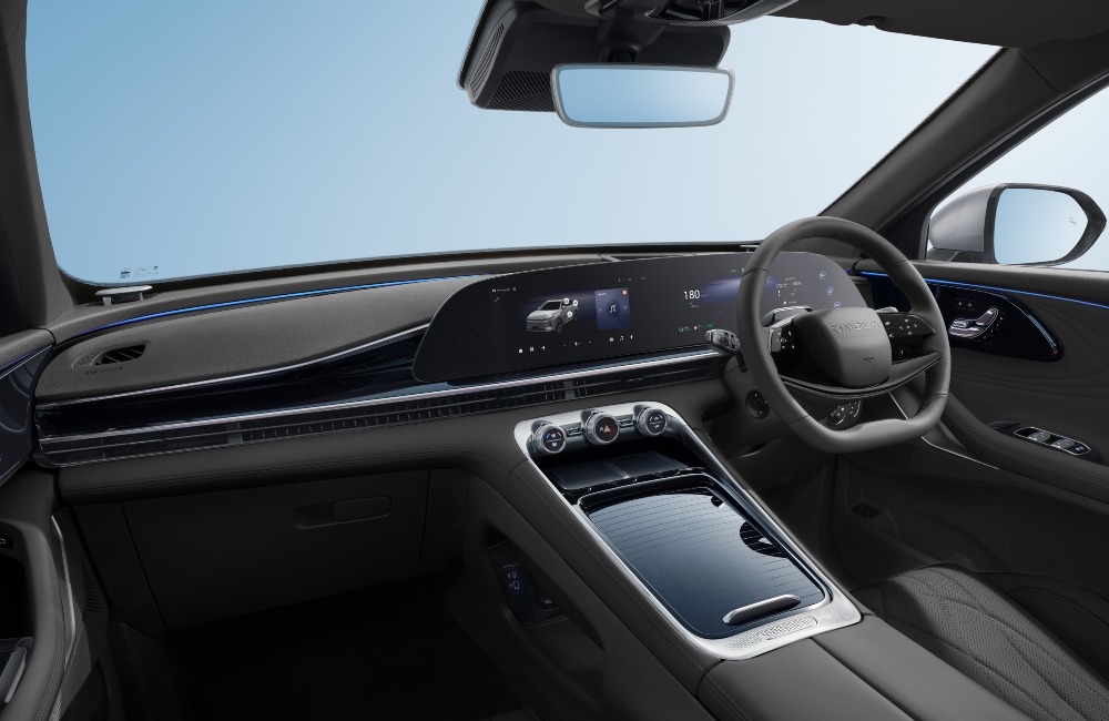 The interior of an OMODA 9 with a focus on the infotainment system, centre console, and driving position.