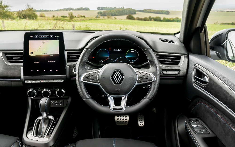 Renault Arkana E-Tech interior, with the steering wheel, digital display and central touchscreen.