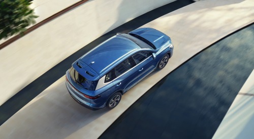 Angled top-down view of a BYD SEALION 5 DM-i moving at speed along a road.