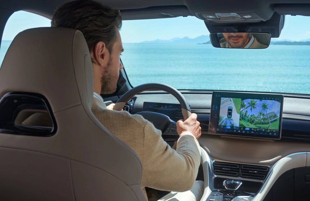 Interior shot of a BYD SEALION 5 DM-i, with focus on the touchscreen infotainment system as the driver uses ADAS to park the car.