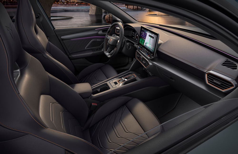 Angled view of entering a CUPRA Leon Estate, showing the comfortable seating, central console, and infotainment system