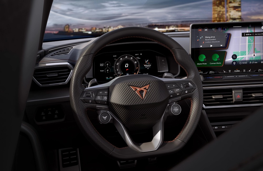 Interior view of the CUPRA Leon Estate, from the perspective of the drivers seat, showing off the infotainment system, steering wheel, and digital cluster.