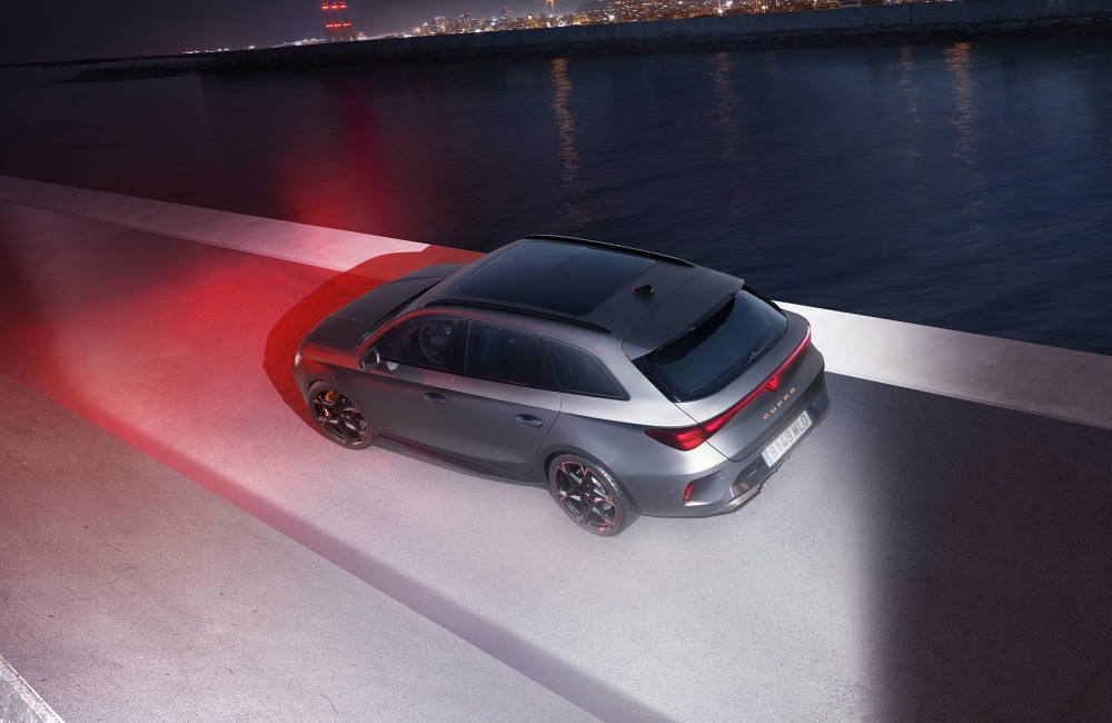 Side profile of a CUPRA Leon Estate in a futuristic setting, with blue and red lighting