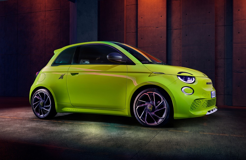 Angled side profile of an Abarth 500e, showing off unique alloy wheels, headlights, and front facade
