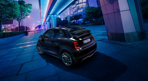 Angled rear view of an Abarth 500e Cabrio, with the convertible roof lowered.