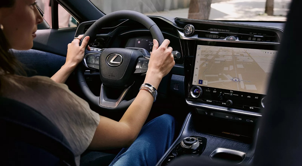 A person driving, using the sat nav of the New All-Electric Lexus RZ; New All-Electric Lexus RZ interior