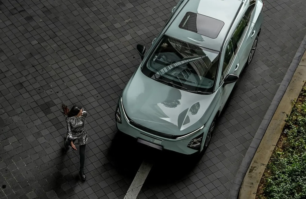 Top down view of a person walking away from an OMODA E5
