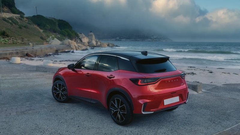 A red Lexus LBX parked near a beach; Lexus approved used cars