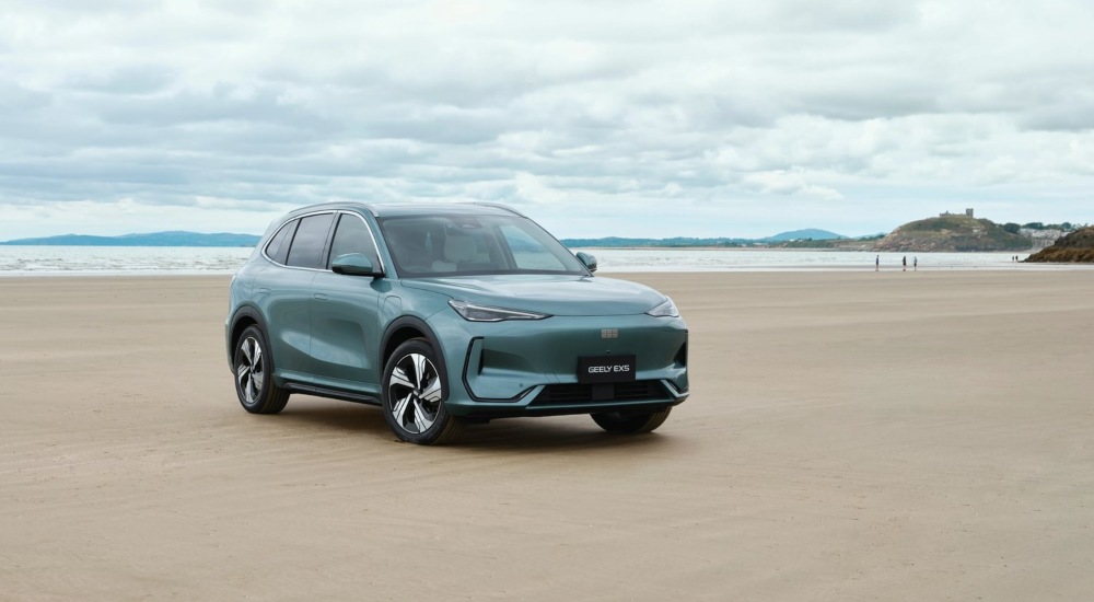 Geely EX5 on Black Rock Sands beach with Criccieth Castle in the background.
