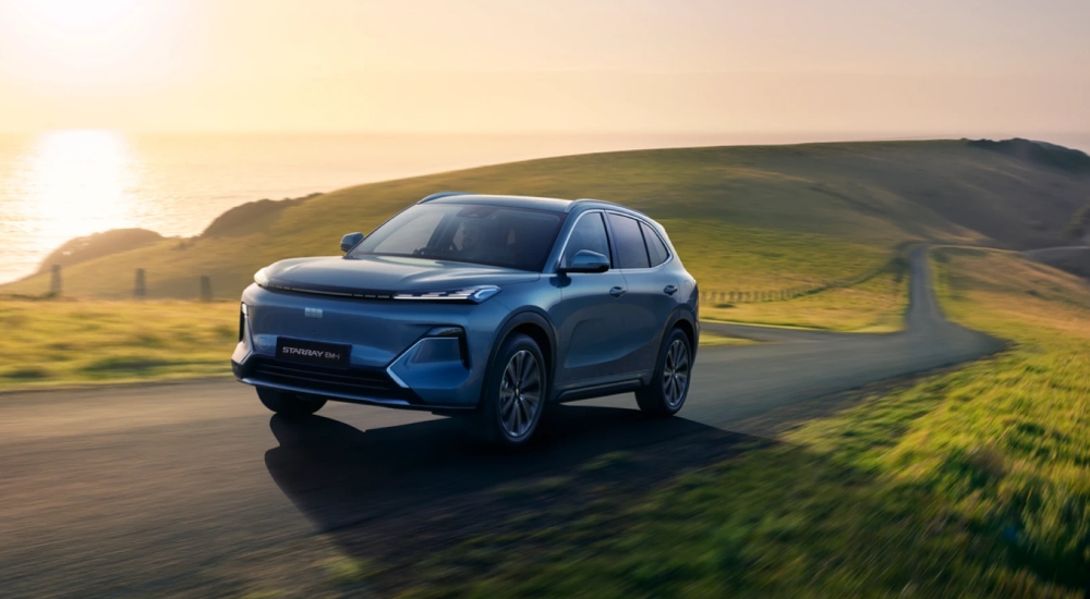 New Geely Starray EM-i in Glacier Blue, front three-quarter view on a coastal road.
