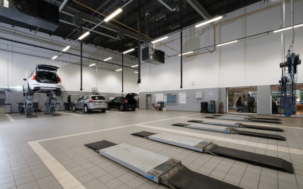 Car service centre with vehicles on lifts and inspection bays.