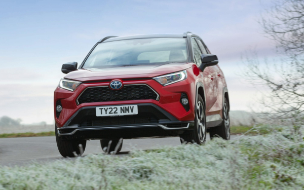 Used Toyota RAV4 PHEV Dynamic in Scarlet Flare driving on a frosty road.