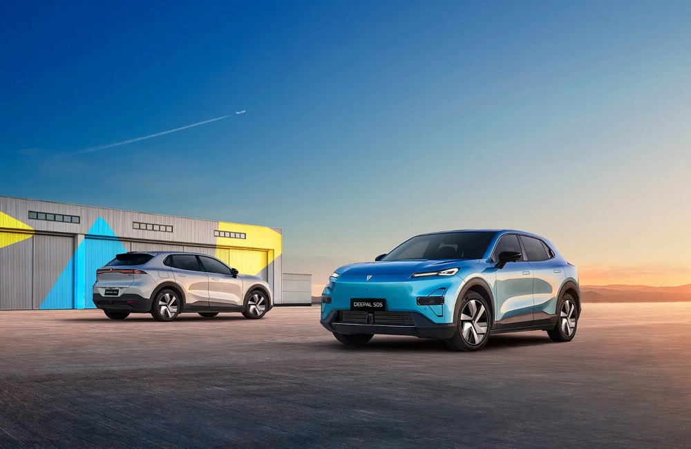 Two Changan Deepal S05 cars, one facing towards the shot and one away, showing off both sides of the vehicle. There is a serene sunset backdrop with mountains.