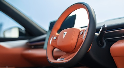 Interior shot of a Changan Deepal S05, showing the orange styling and a close up of the steering wheel