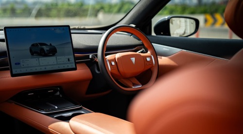 Interior view of the Changan Deepal S05, showing off the orange detailing and driver cockpit. The central screen shows information about the car.
