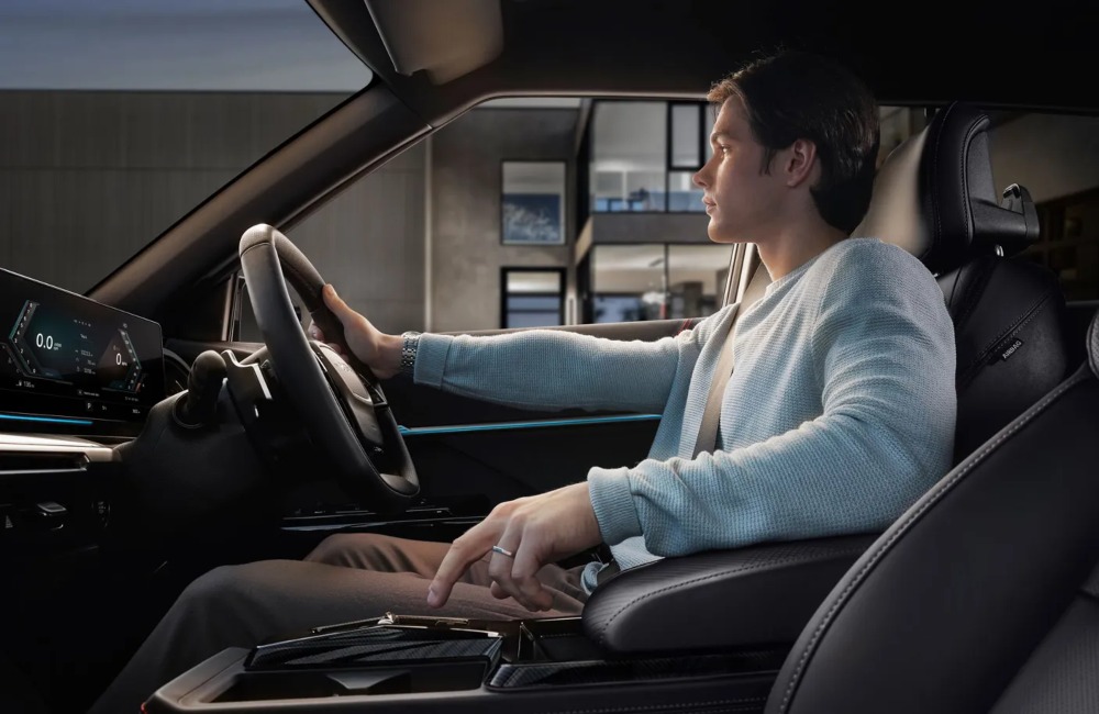 Person sat in a KGM Actyon Hybrid driver's seat, utilising the central console.