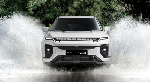 KGM Actyon Hybrid driving through water, splashing the water outward from the car on both sides.