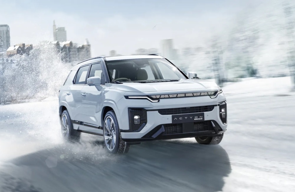 KGM Actyon Hybrid driving through snow, with snow spraying behind the car