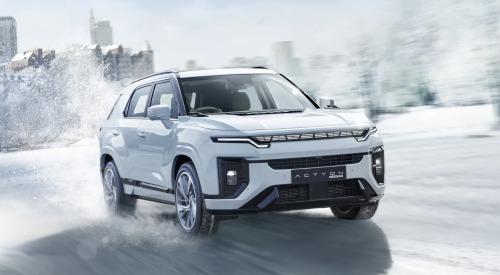 KGM Actyon Hybrid driving through snow, with snow spraying behind the car