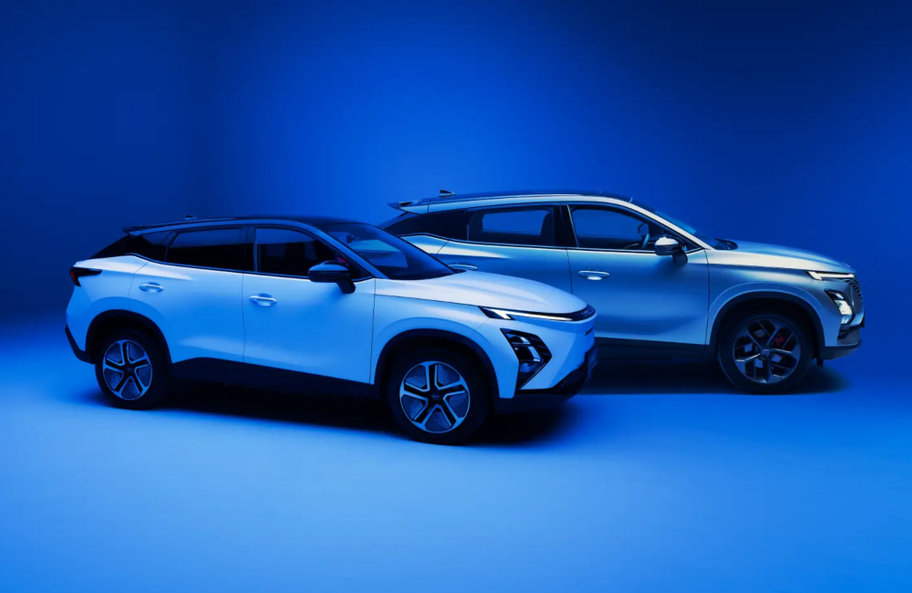 Photoshoot of two OMODA cars. The cars are posing to the right, showing off their side profiles. They are stages on a blue backdrop.