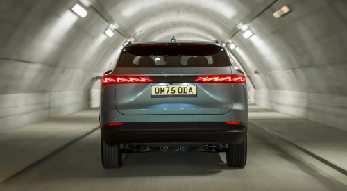 Rear view of an OMODA car travelling at speed down a lit tunnel, having a focus on the rear LED lighting.
