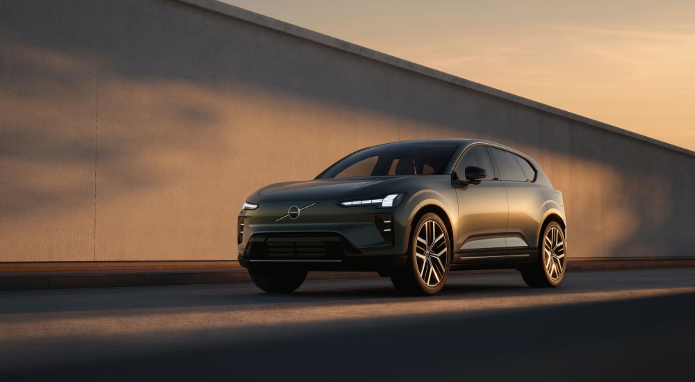 Front three-quarter view of the Volvo EX60 in Forest Lake driving alongside a concrete wall.