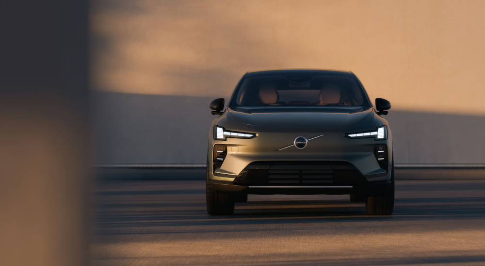 Front view of the Volvo EX60 in Forest Lake with signature LED headlights illuminated.