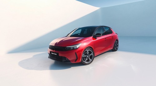 A red Vauxhall Corsa posing at an angle towards the camera in a photoshoot with an all-white backdrop.